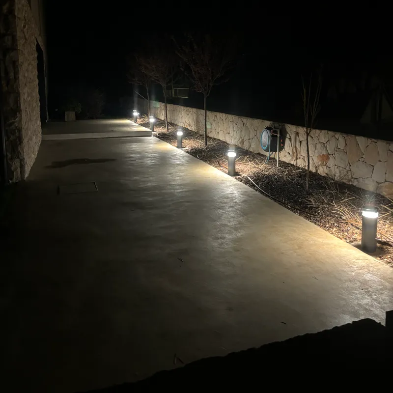 Vanjska rasvjeta uz kameni zid u večernjim satima